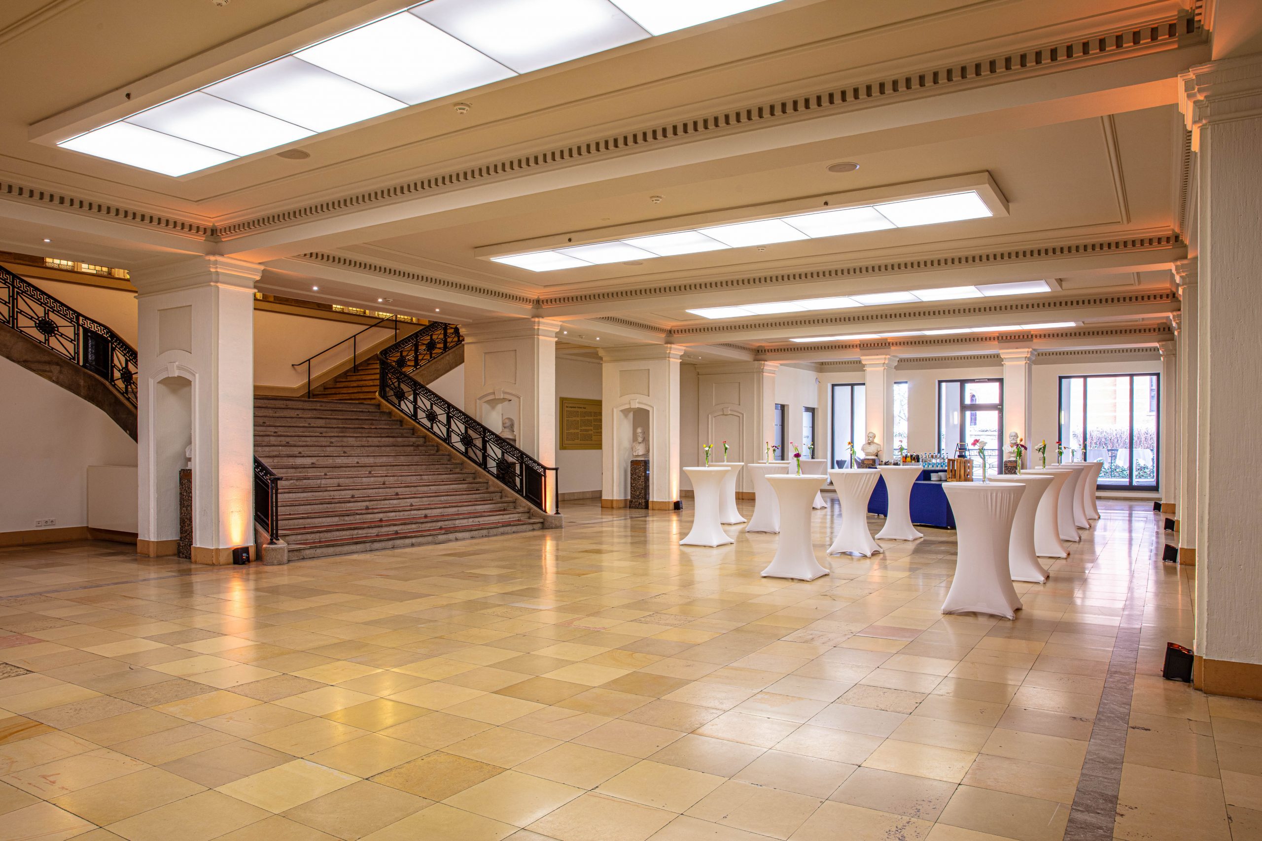 Historisches Foyer im Erdgeschoss des LVH Langenbeck Virchow Haus Berlin mit Marmorboden, Treppenaufgang und Stehtischen als Eventlocation für Empfänge