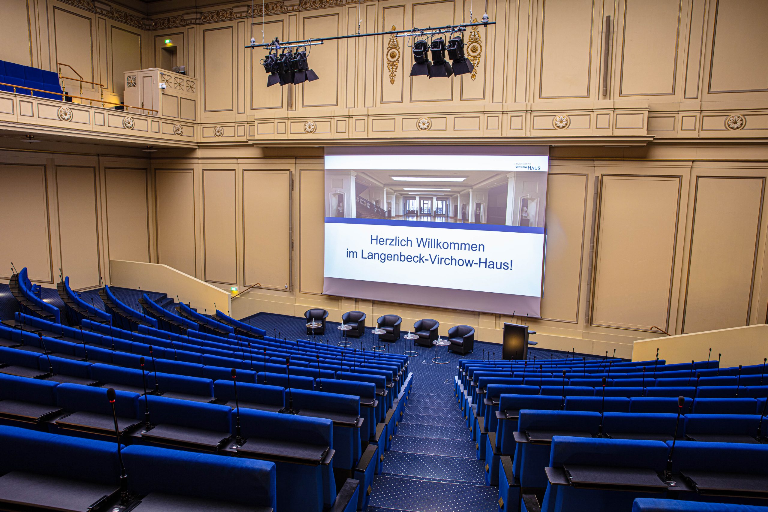 Hörsaal im LVH Langenbeck Virchow Haus Berlin mit blauen Sitzreihen, Bühne und Leinwand als Eventlocation und Drehort für Filmaufnahmen