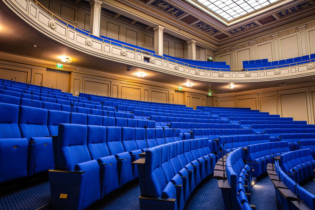 Hörsaal im LVH Langenbeck Virchow Haus Berlin mit blauen Sitzreihen und Emporen als Eventlocation und Drehort für Filmaufnahmen