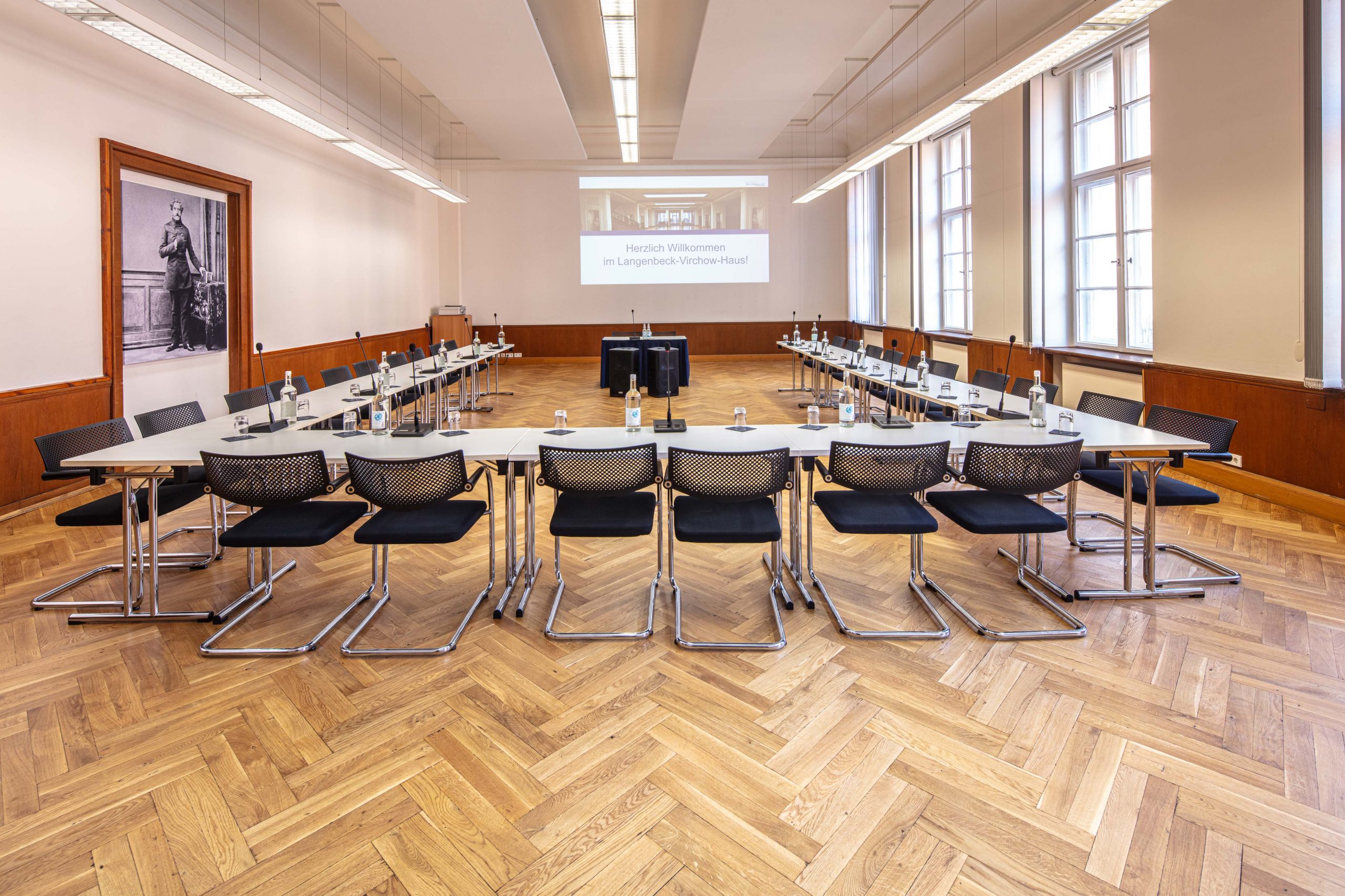 Tagungsraum Langenbeck im LVH Langenbeck Virchow Haus Berlin mit Konferenztischen, Stühlen und Leinwand für Seminare
