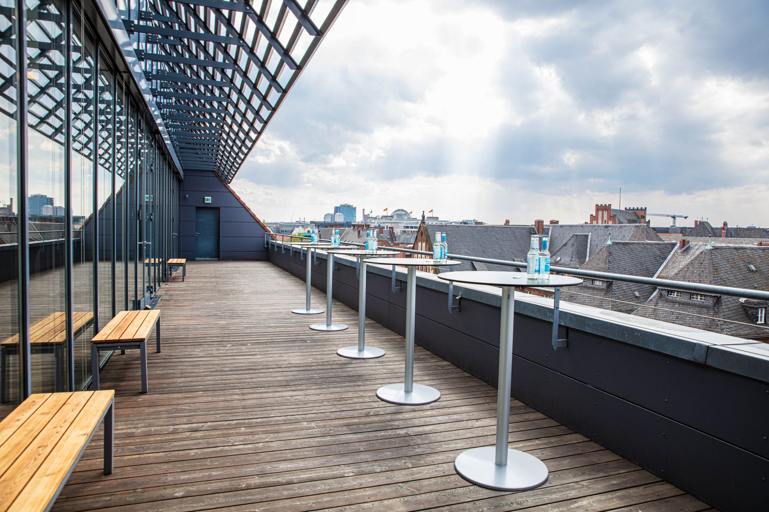 Dachterrasse im Langenbeck-Virchow-Haus in Berlin mit Sitzgelegenheiten und Stehtischen, barrierearm erreichbar und mit Panoramablick über die Stadt