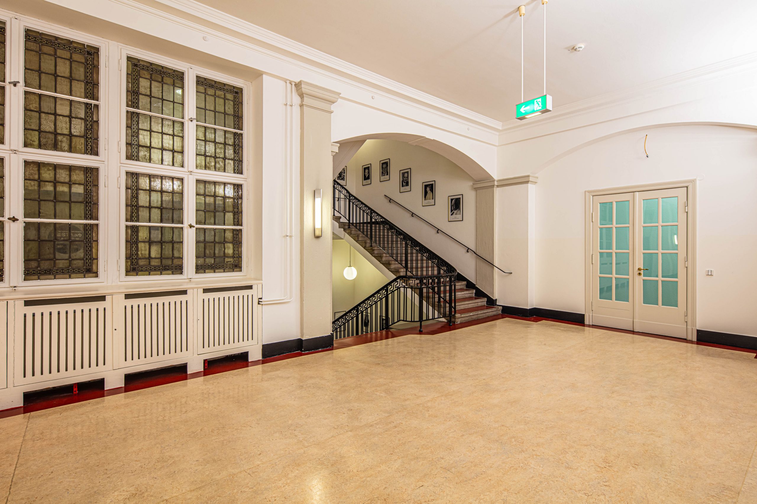 Foyer im 2. Obergeschoss des Langenbeck-Virchow-Hauses in Berlin mit Blick auf die historische Treppe und große Fensterfront.