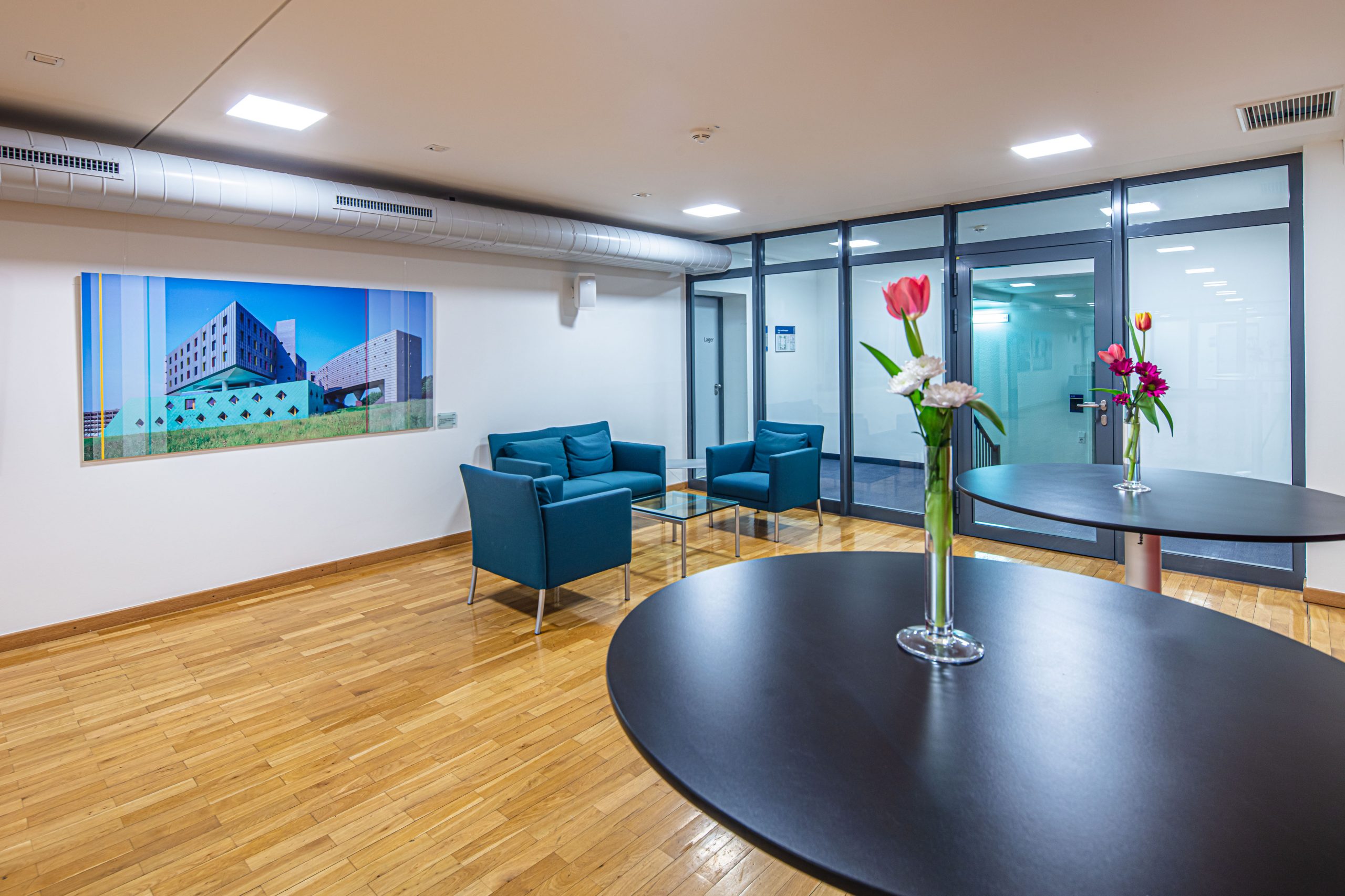 Barrierearmes Foyer im 4. Obergeschoss des Langenbeck-Virchow-Hauses in Berlin mit moderner Lounge-Ecke und Stehtischen, ideal für Networking und Pausenbereiche bei Veranstaltungen